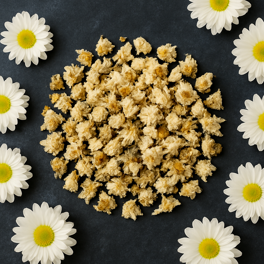 Chrysanten bloementhee flatlay: gedroogde bloemknoppen met witte bloemen op donkere achtergrond